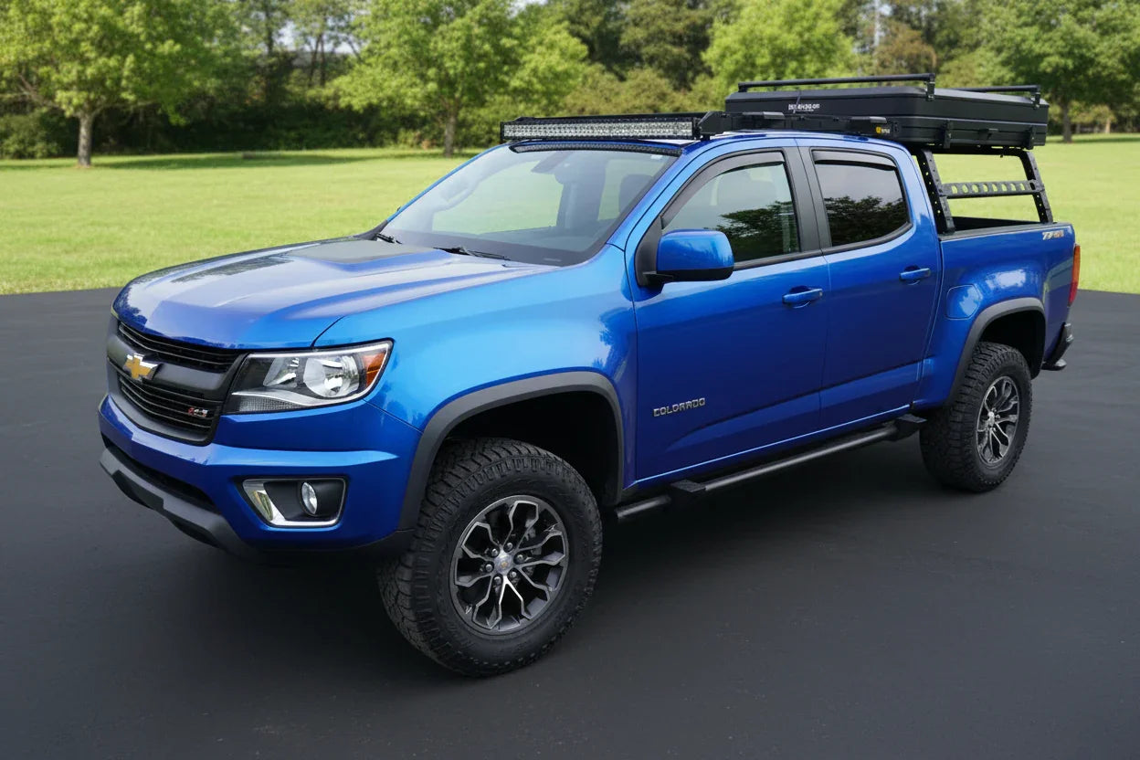 Blue Chevy Colorado ZR2 truck with off-road sidesteps, roof rack, and outdoor gear accessories.